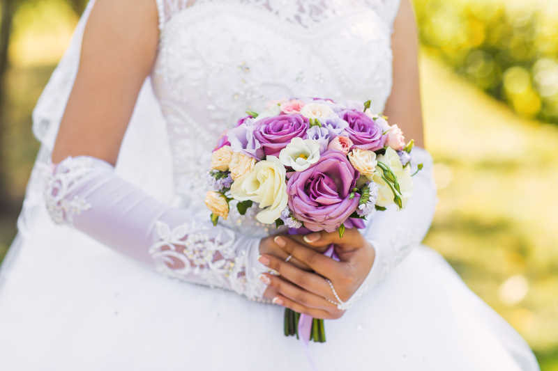 穿着白色婚纱的新娘和手里的捧花