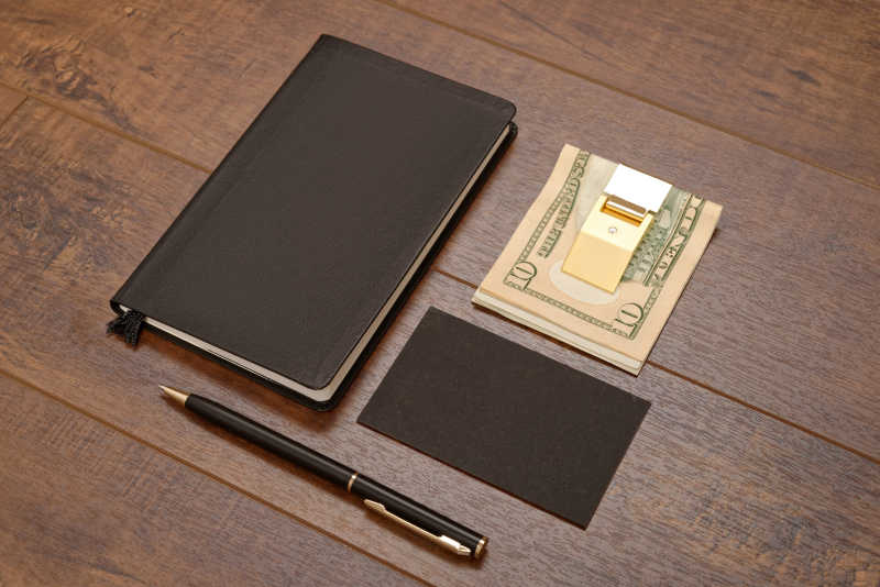 棕色木板上的笔记本和钢笔黑色空白名片