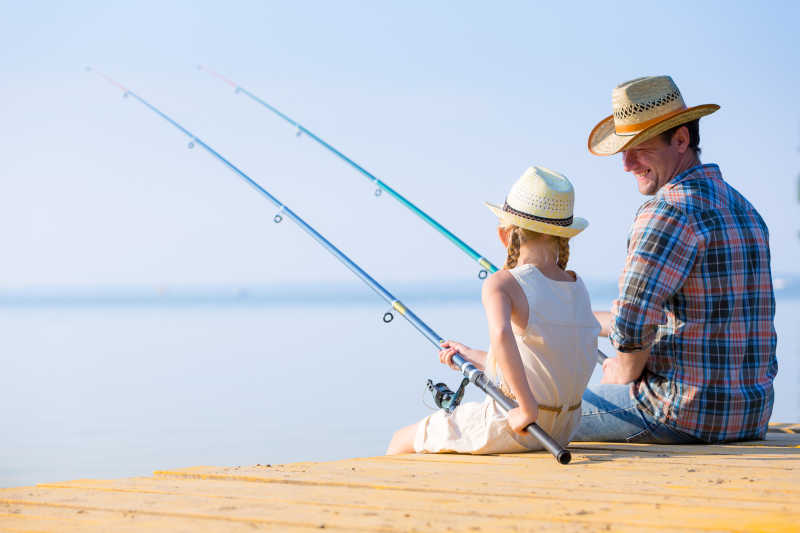 父亲和女儿在码头钓鱼