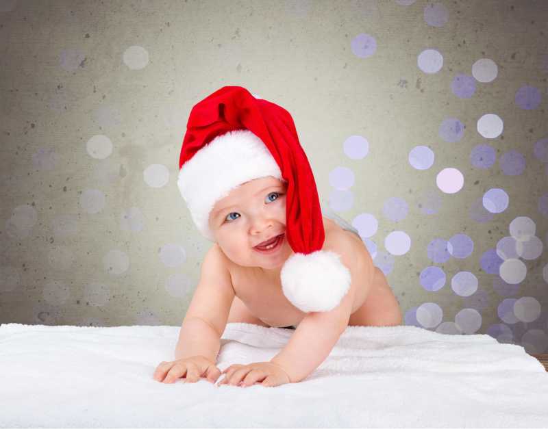 戴着圣诞帽的可爱大笑的婴儿