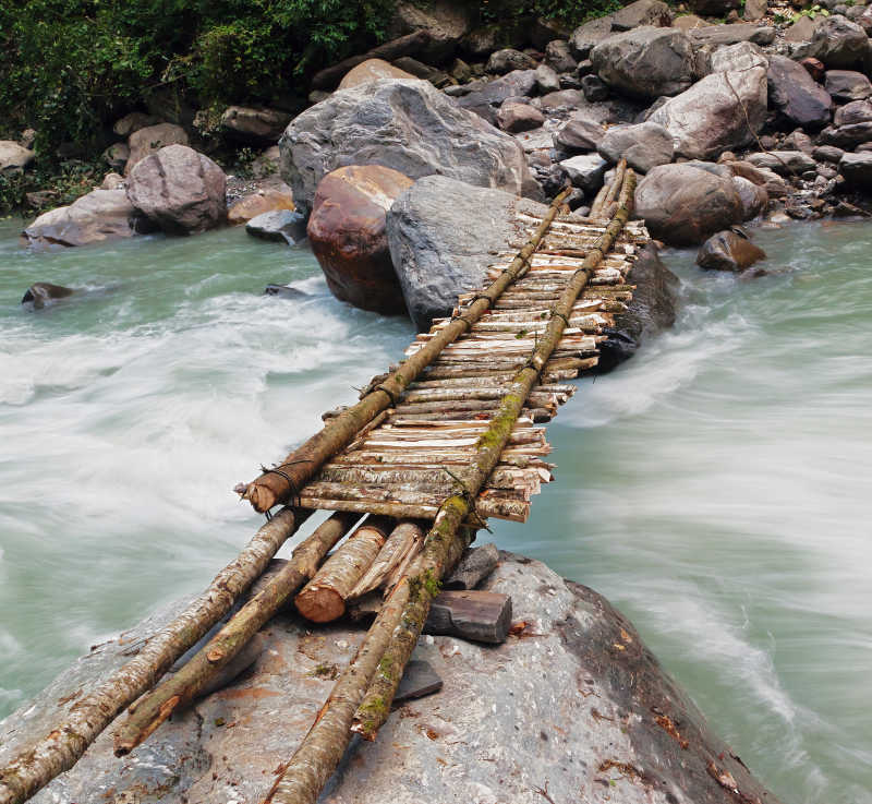 湍急的河流上搭设的简易桥梁