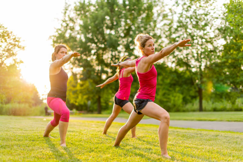 妇女在公园练习瑜伽姿势