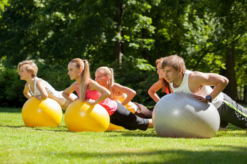 公园中年轻的人使用健身球健身