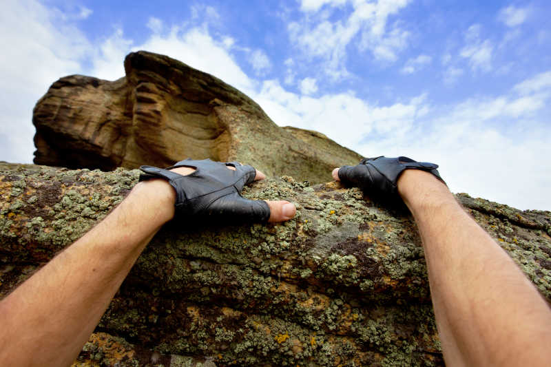 正在攀登岩石的双手
