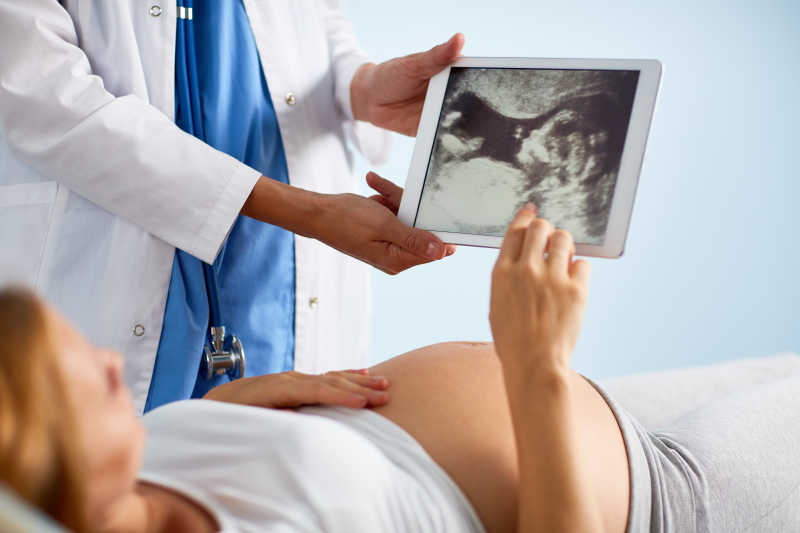 躺着孕检的孕妇通过B超看自己的宝宝