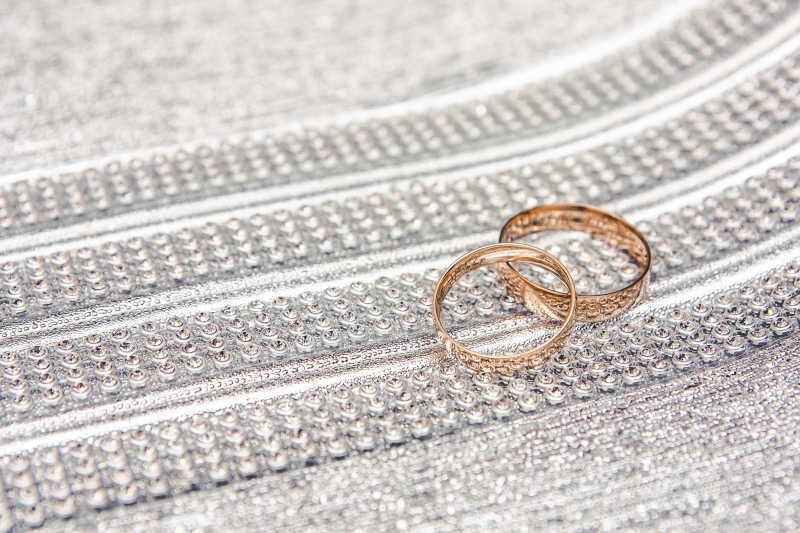 闪亮板上的两枚金色结婚戒指