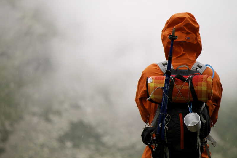穿着橙色登山服的徒步旅行者看到的云海风景