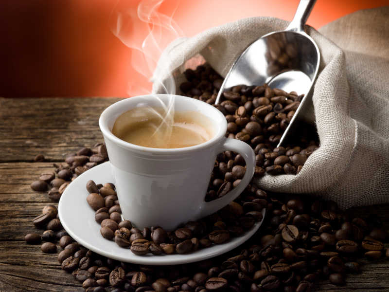 白色杯子里的热咖啡和咖啡豆