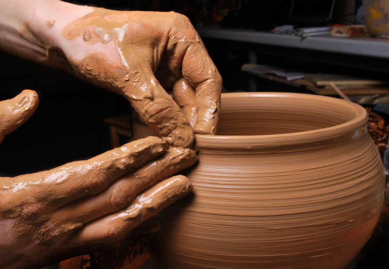 陶工的手在圆上创造一个瓮
