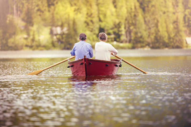 在湖面上划木船的夫妇