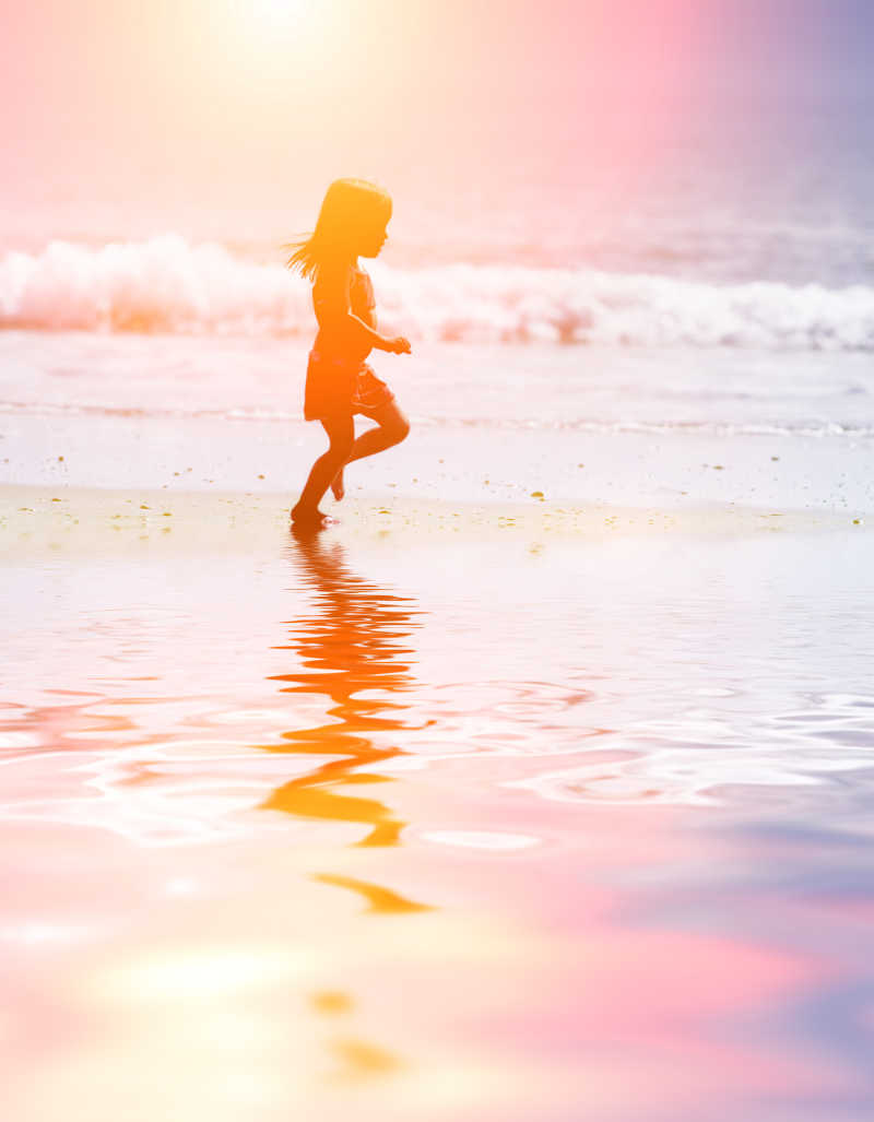 日落时分在海滩上奔跑的孩子