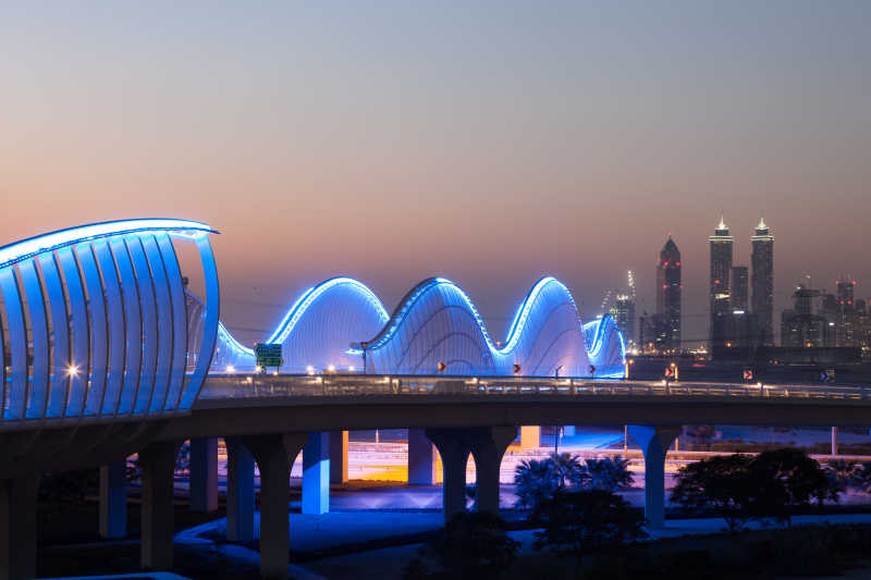 波浪形的迈丹桥在迪拜在夜间照明