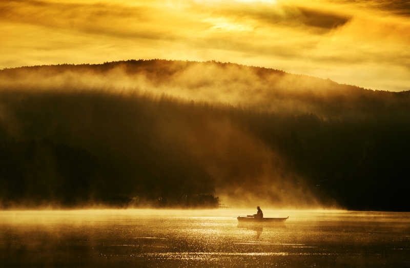 在阳光照耀下湖上泛舟背景