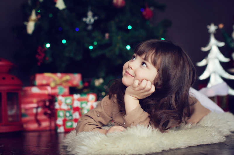 圣诞环境中躺在毛毯上的小女孩