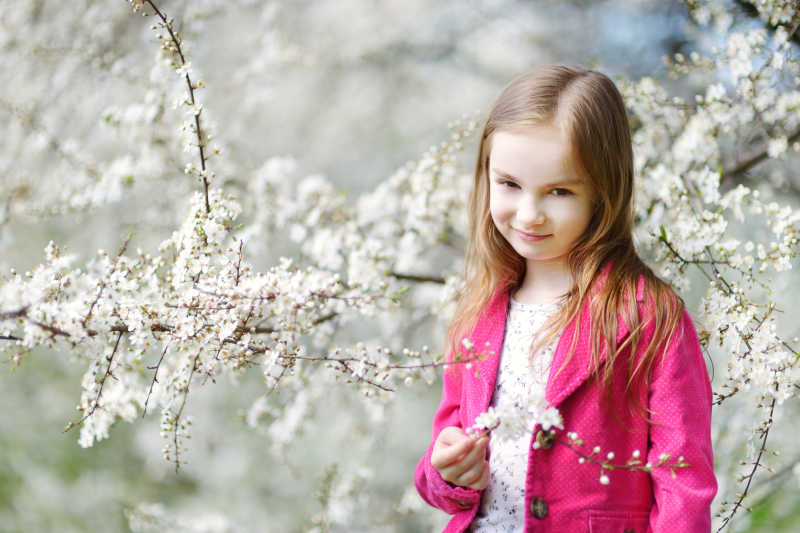 开满樱花的樱花树下的小女孩