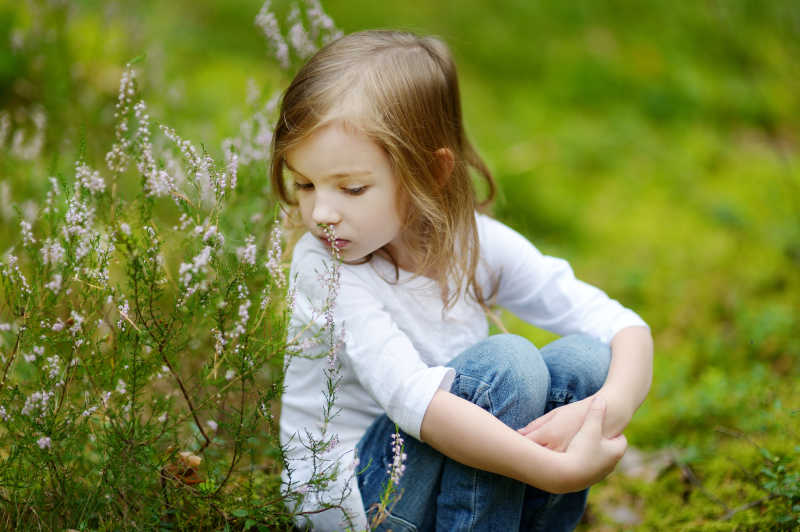 夏日森林里坐在草地上的小女孩
