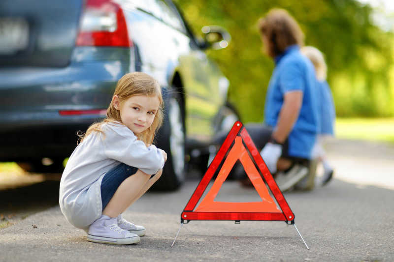 车辆故障三角警示牌旁的小女孩