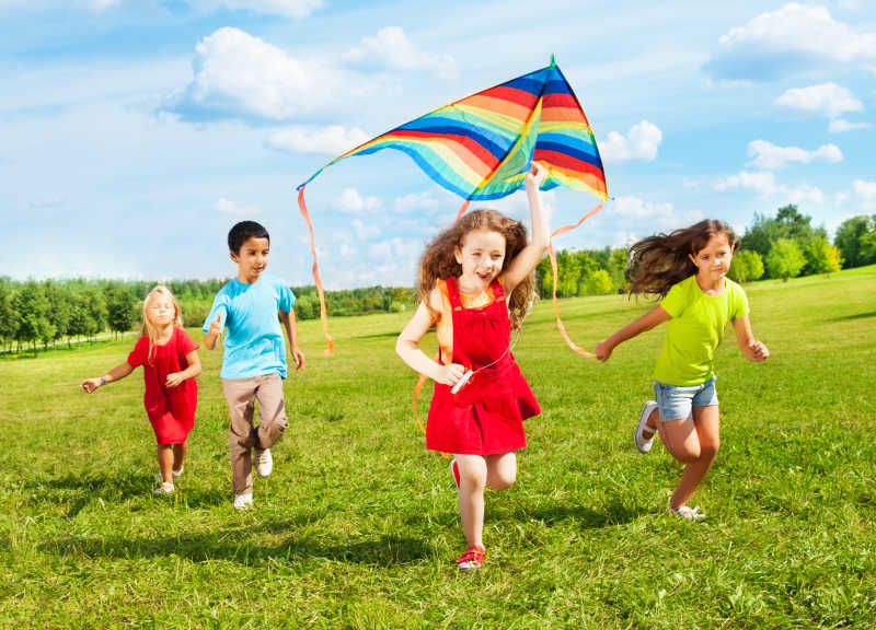 草地上放风筝的四个孩子