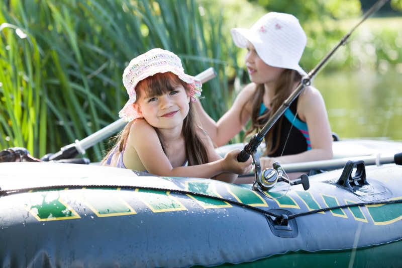 夏日湖边钓鱼的两个小女孩