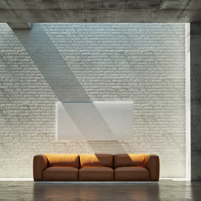 阳光下室内的沙发和墙上的空白海报特写
