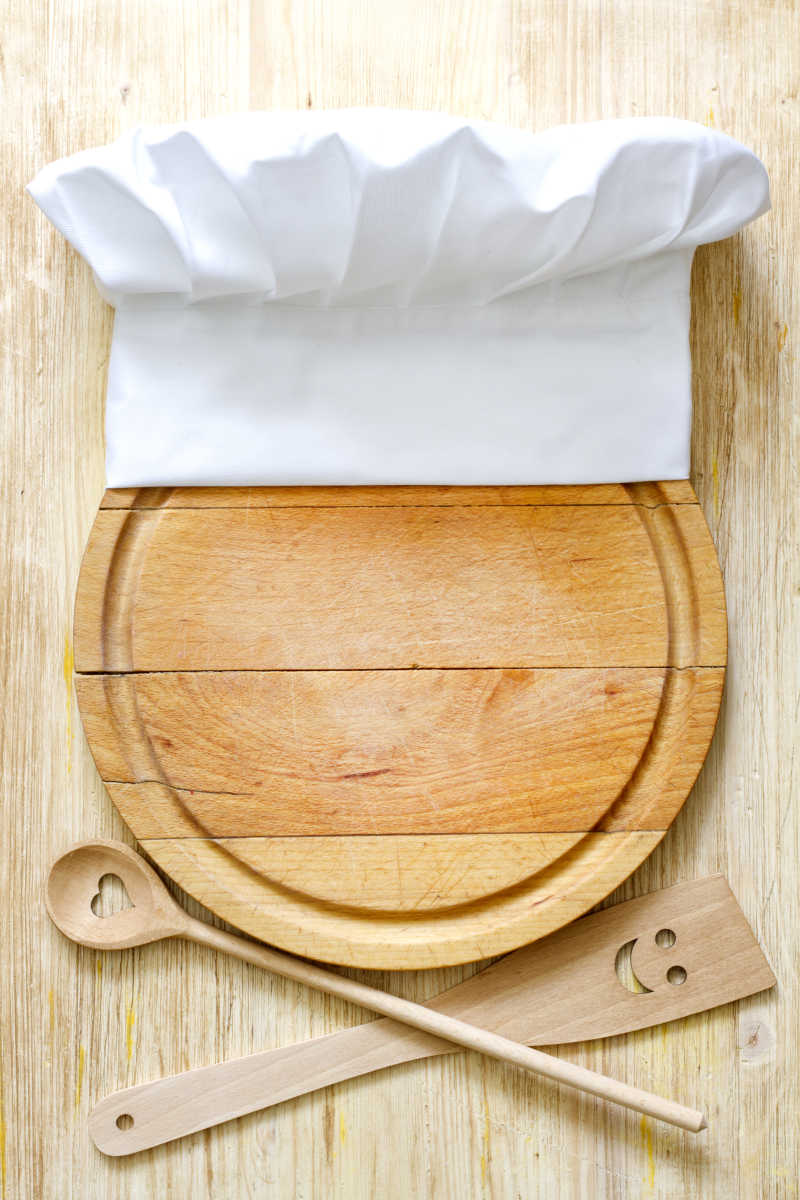 砧板上的厨师帽与木质餐具