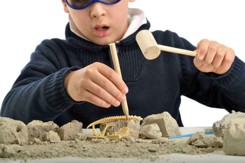 模仿考古挖掘恐龙化石的男孩