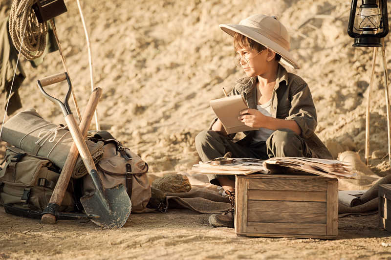 坐在阳光下研究考古笔记的男孩