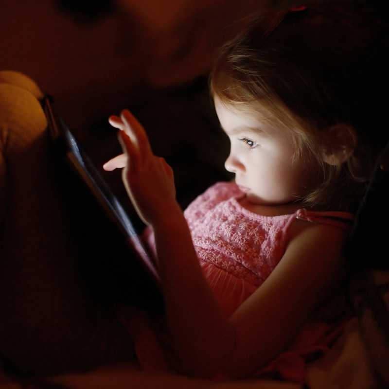 一个小女孩正专心的玩着平板电脑