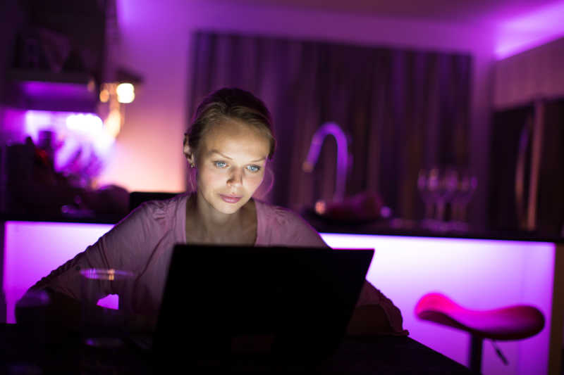 紫色背景中一个女孩正在玩电脑