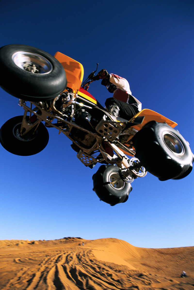 一个骑着沙滩车的人在空中飞翔的男人