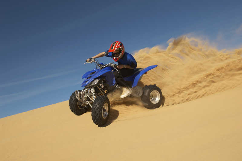 沙漠里骑着四轮ATV摩托车的人