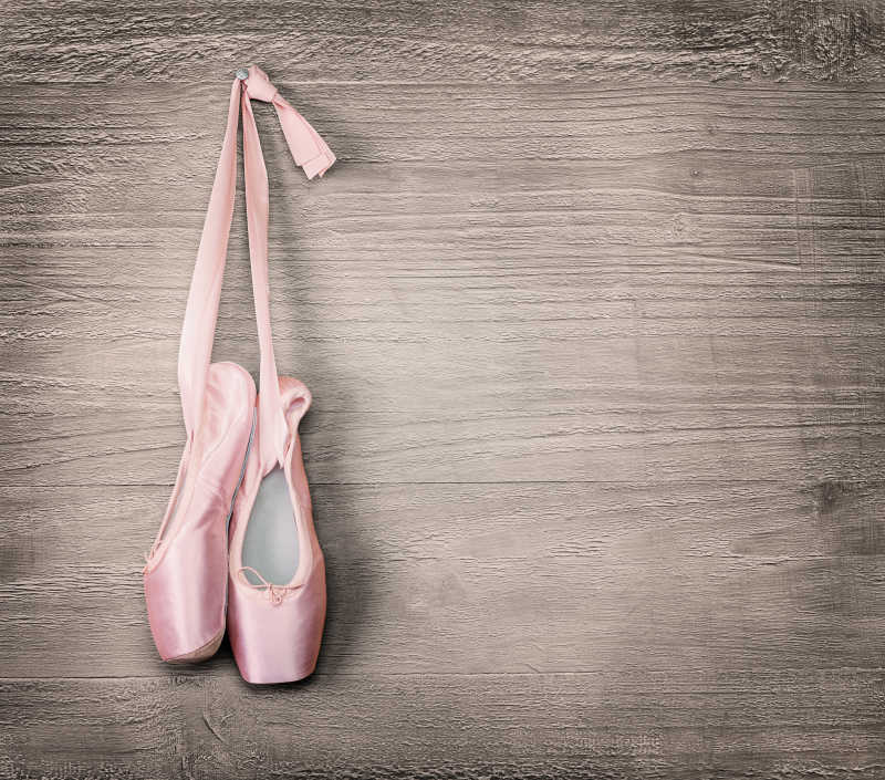 挂在木板上的粉色芭蕾舞鞋