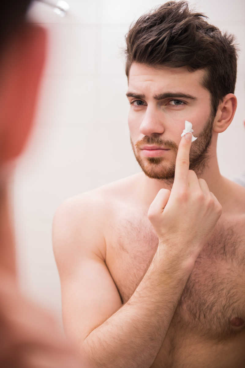 一个年轻男人在往脸上涂剃须膏