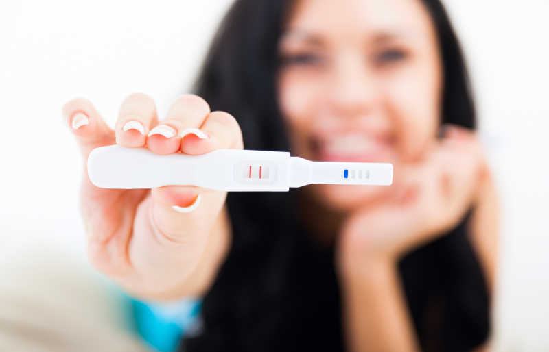 怀孕测试阳性结果微笑的女人