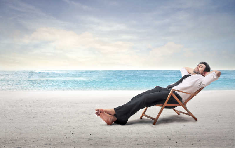 男人躺在沙滩的椅子上休息