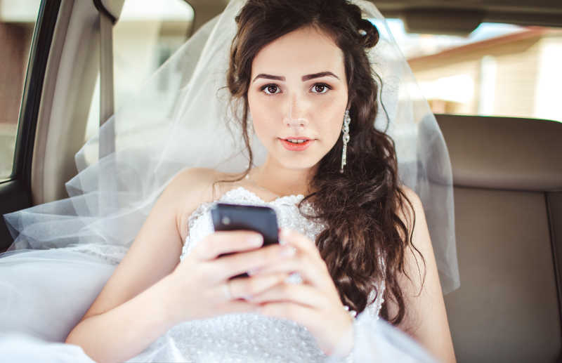 在做车中玩手机的新娘