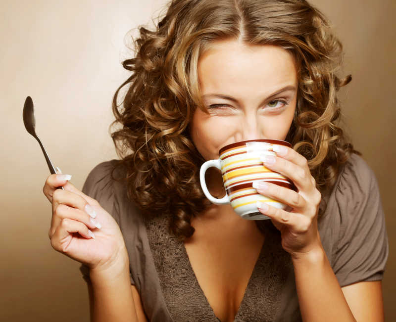 美女喝咖啡手里拿着汤匙