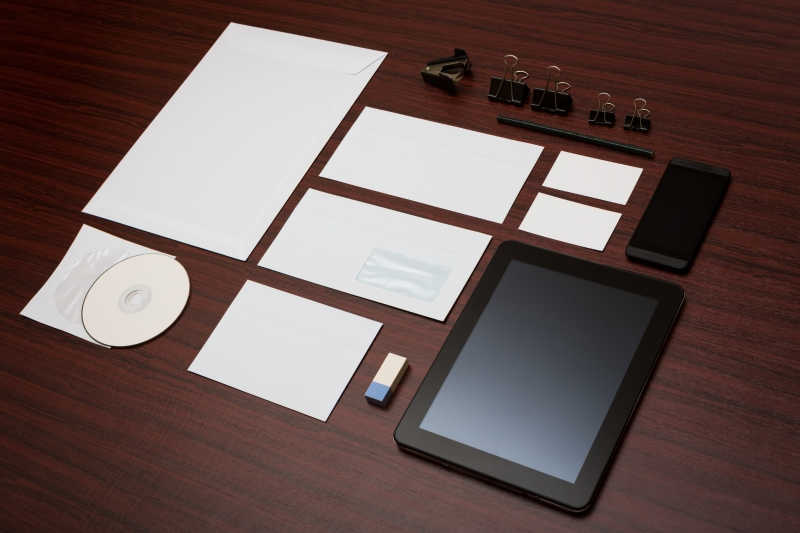 棕色木桌上的空白纸片与办公用品
