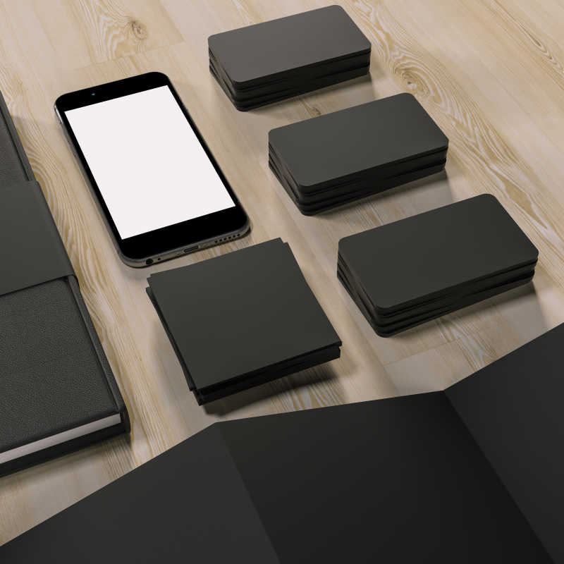 木桌上的黑色卡片和手机