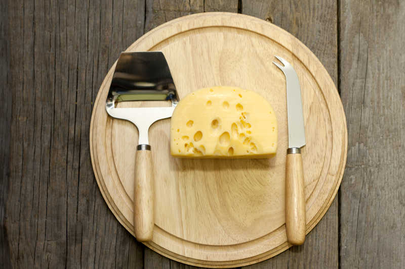 圆木板上的奶酪和餐具