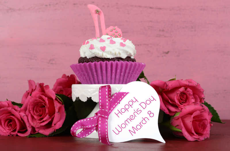 3月8日粉红色木背景的蛋糕和玫瑰花