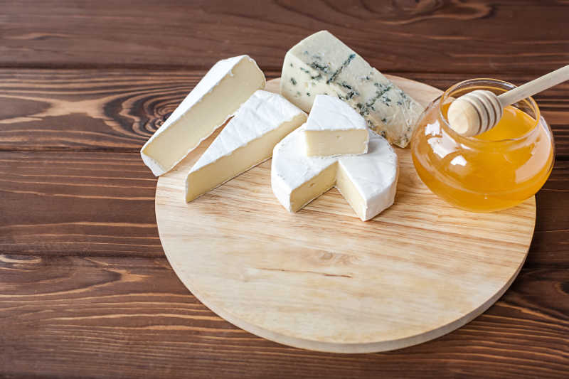 木板上的奶酪和蜂蜜