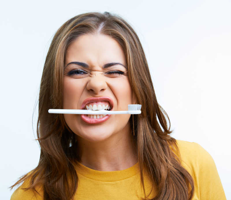 女人牙齿咬着牙刷做表情