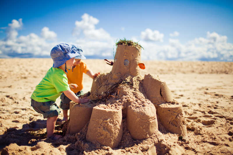 两个孩子在沙滩上堆沙堡