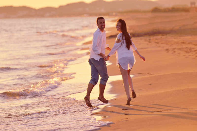 开心的夫妇在海边跑步