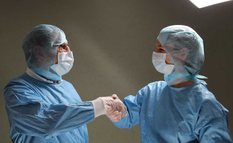 两个医生在手术成功工作后握手