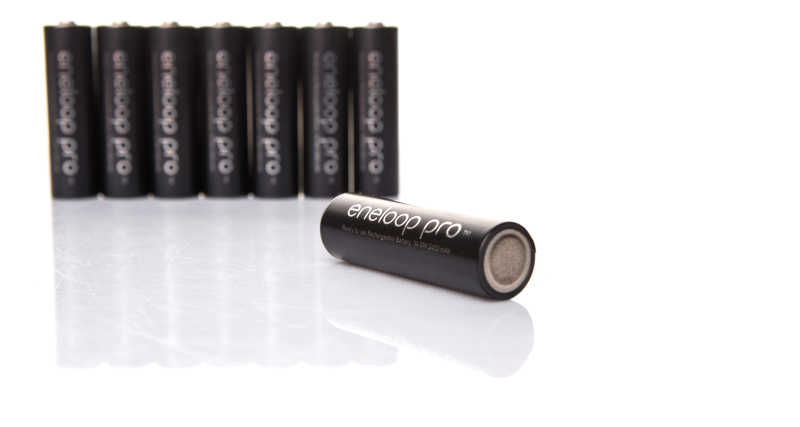 白色背景下白色桌面上放置的黑色eneloop Pro可充电AA电池