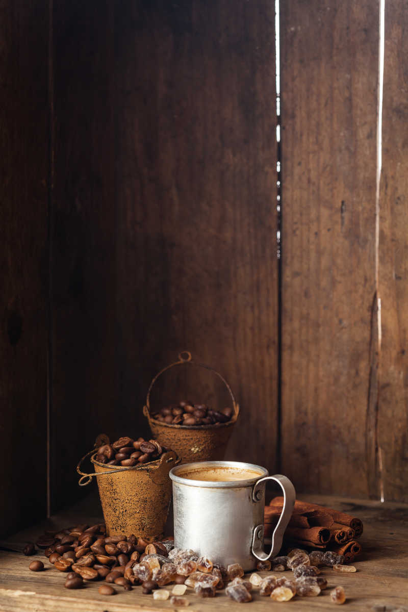木质背景下咖啡杯加肉桂和红糖