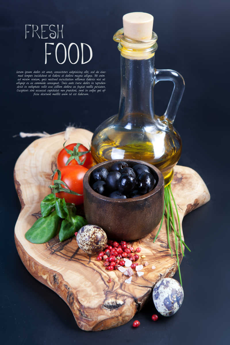 木制桌子上的一瓶油和黑橄榄番茄