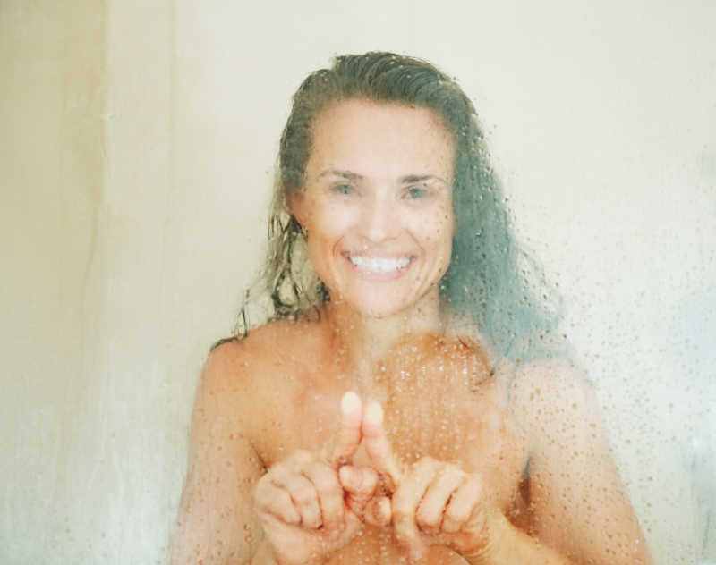 美女在洗澡引起的玻璃热气上画图